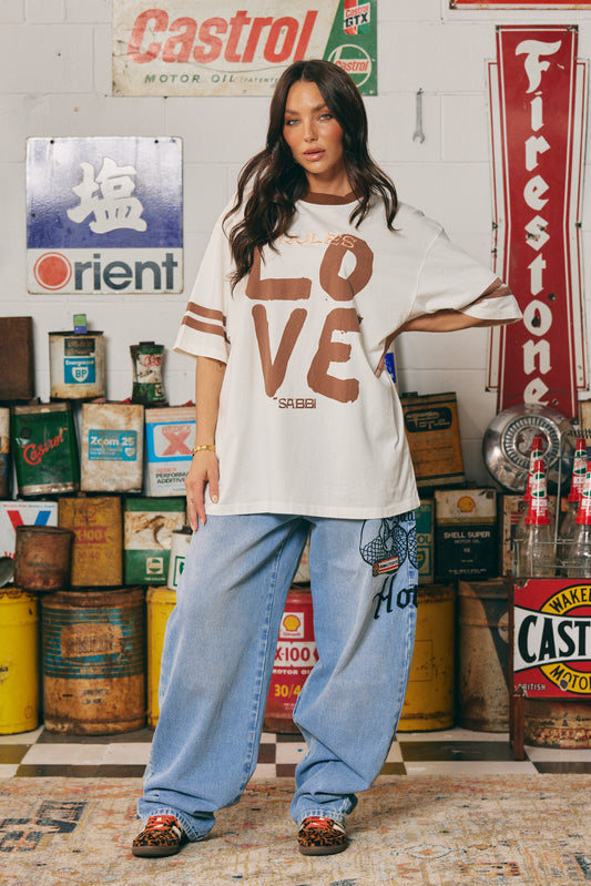The Love Revolution Tee – Off White
Make a statement in soft neutrals with the Love Revolution Tee – Off White. Featuring bold chocolate-toned "LOVE" lettering, subtle pink rules detail, and varsity-inspired sleeve stripes, this oversized tee blends comfort with confident energy. Crafted from soft cotton with a relaxed fit, it's perfect for laid-back days or styled up with standout denim. Whether you're breaking the rules or rewriting them — this tee is all about leading with love.

