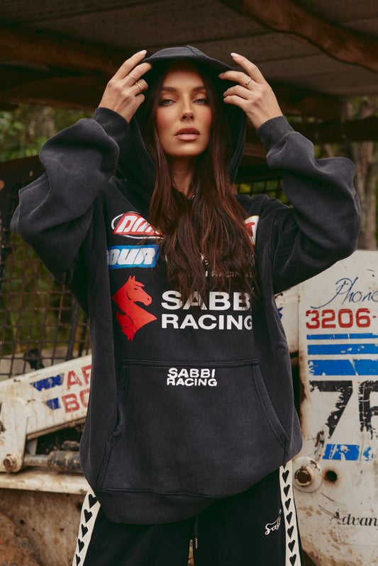 DON'T QUIT YOUR DAY DREAM HOODIE – BLACK

Rev up your streetwear game with the Don’t Quit Your Day Dream Hoodie in black – where off-duty comfort meets high-octane style. Inspired by bold motorsport energy, this oversized hoodie features striking retro racing graphics, the iconic Sabbi double-horse logo, and powerful statement patches that command attention from every angle.