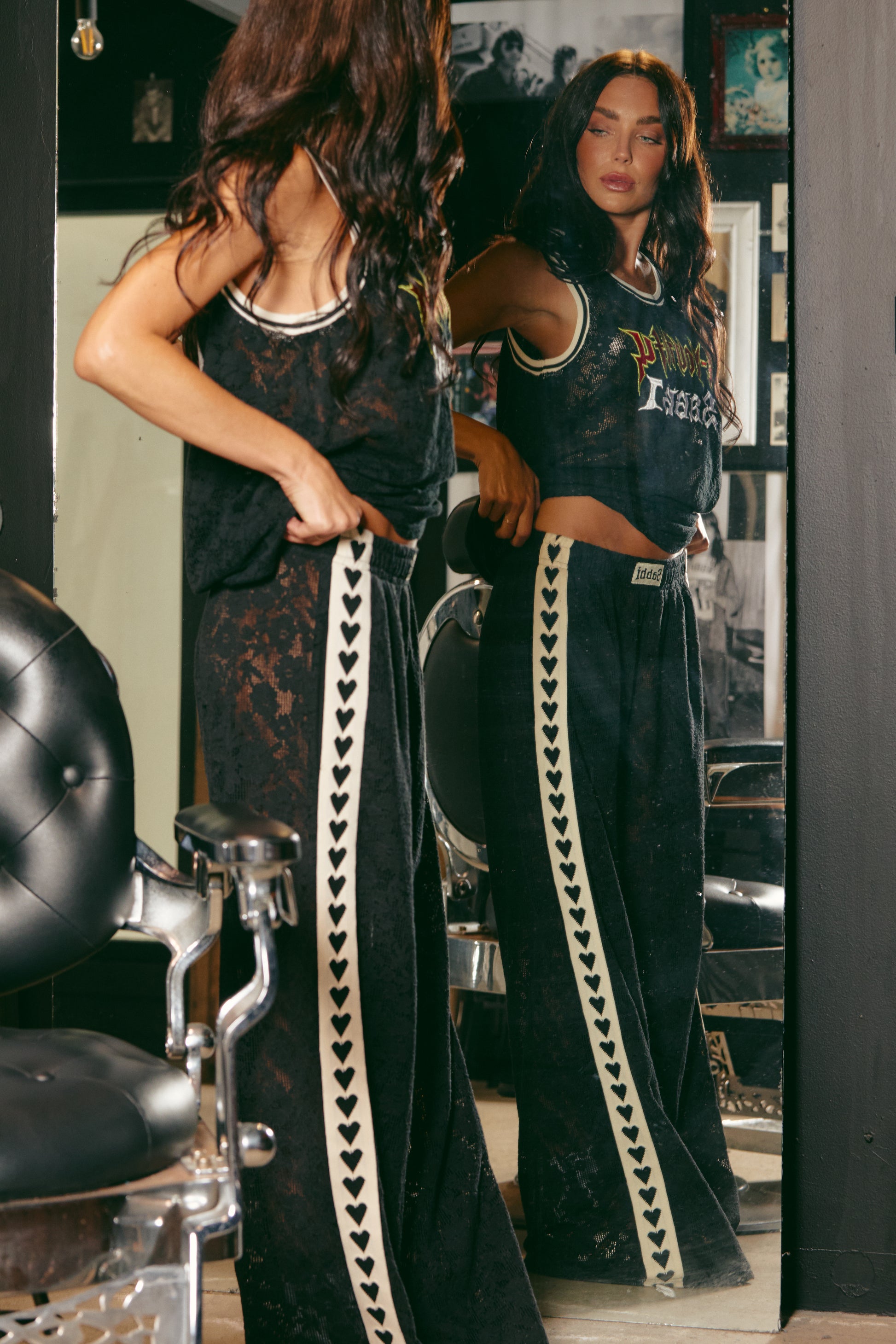 Make a statement in The Raving Hearts Lace Pants - Black, where grunge meets goddess. Crafted from soft, floral lace with a sheer finish, these pants embody the perfect clash of romance and rock ‘n’ roll. The relaxed, wide-leg silhouette flows effortlessly while the contrast heart trim running down each leg adds a bold, playful twist.