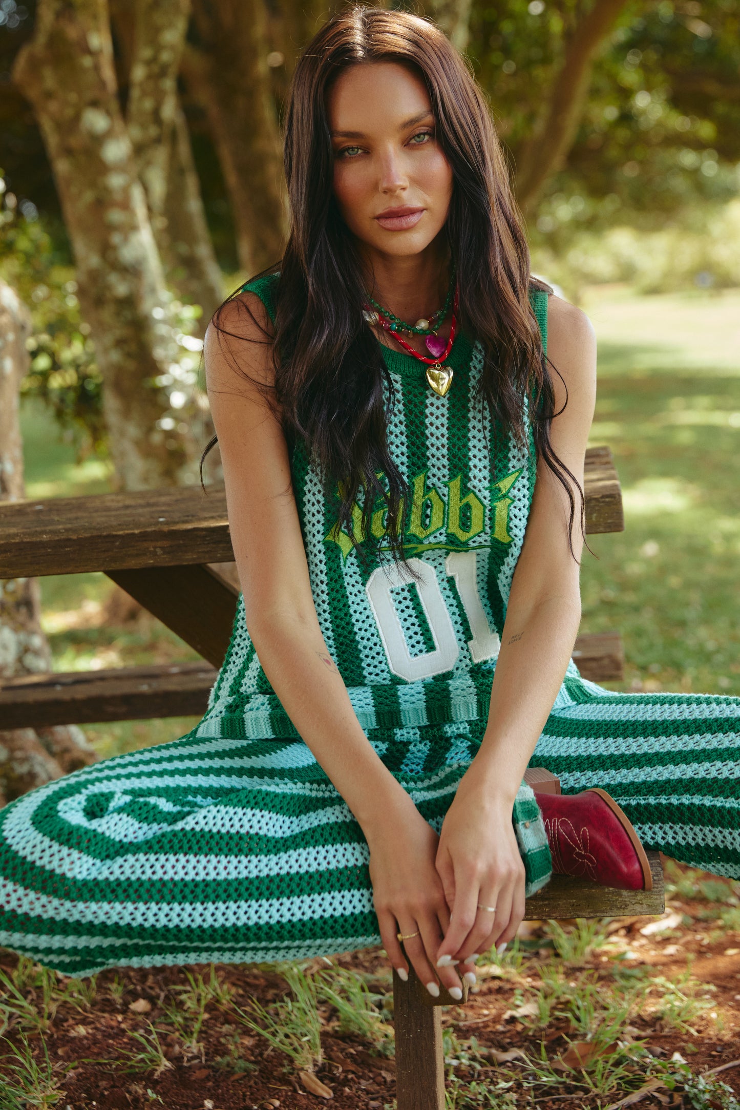 THE KNIT B-BALL SINGLET – GREEN STRIPE - GREEN

Meet the knit that brings big energy everywhere it goes. The Knit B-Ball Singlet in Green Stripe is a vibrant, retro-sport moment crafted for the bold, the playful, and the ones who refuse to blend in. Hand-crocheted with wide alternating green tones, this breathable mesh singlet delivers effortless comfort with serious statement power.