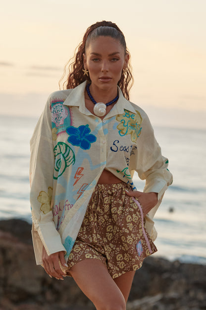 Sabbi - Meet the shirt that does it all. The Don Julio Shirt in Cream – Seas The Day is your throw-on-and-go statement piece, blending effortless coastal cool with bold, hand-drawn Sabbi artwork. Lightweight, breezy and intentionally oversized, it’s made for salty skin, sun-faded afternoons and dancing straight from beach to bar.