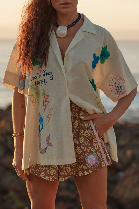 Sabbi - Meet your new coastal statement piece. The Patron Shirt in Cream Seas the Day is relaxed, expressive and effortlessly cool—made for salty air, sun-faded afternoons and spontaneous adventures. Featuring playful hand-drawn graphics inspired by beach days and carefree living, this shirt brings art and attitude together in one easy throw-on layer.