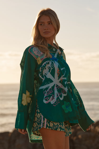 Sabbi - Meet your statement layer for sun-soaked days and golden-hour nights. The Don Julio Shirt – Green is effortlessly cool with a relaxed, oversized fit and a sheer, lightweight feel that moves beautifully with you. Drenched in rich green tones and detailed with playful Seas the Day artwork, this piece brings vintage surf energy with a bold Sabbi twist.