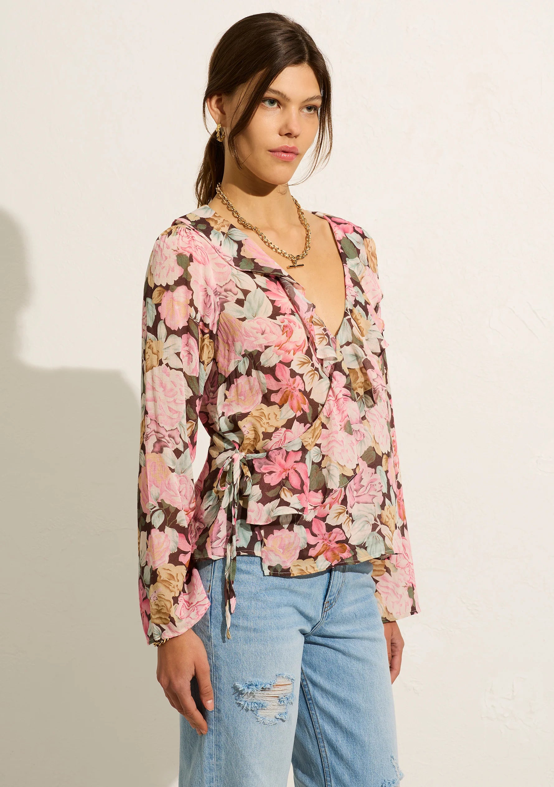 The Sophia Elda Wrap Blouse is crafted from a cotton blend in our feminine blush floral. Featuring a functional wrap design, a V neckline with ruffle details and a choir boy sleeve.