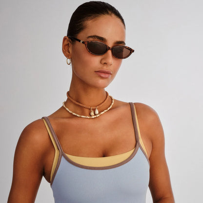 Channel early ‘90s nostalgia with DUSKFALL, a sleek slimline oval frame designed for a bold yet effortless statement. Inspired by vintage silhouettes, this refined design features smooth curves, polished accents, and a streamlined fit, making it the perfect balance of classic and contemporary.

• Finished in a tort frame with brown mono lenses.
• A lightweight, durable and impact resistant polycarbonate frame.
• Fitted with shatterproof and scratch resistant polycarbonate lenses.