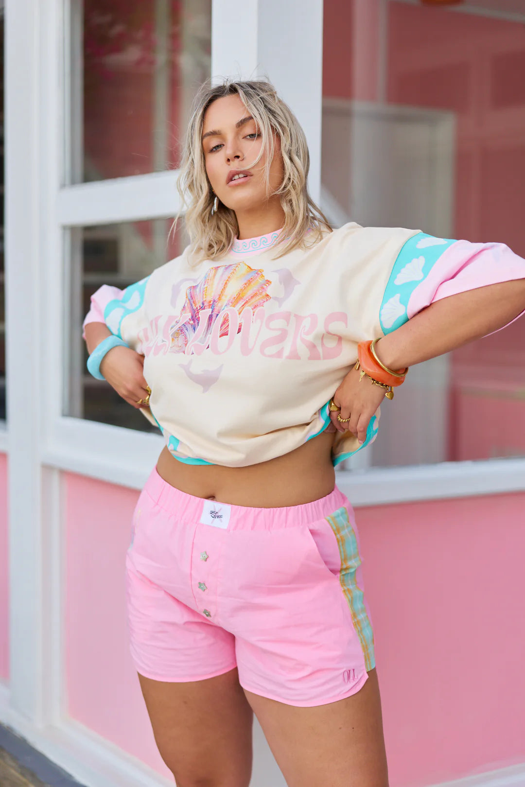 Only Lovers Left - The Shell Club Boxer Short is a bold take on summer nostalgia… easy to wear, instantly fun, and full of thoughtful detail. Crafted from 100% washed cotton, they’re lightweight, durable, and made for endless warm-weather days. Contrast tartan panels run down each side, Mother of Pearl star buttons shimmer at the front, and subtle shell embroidery traces the pocket, a little nod to collecting seaside treasures along the way.&nbsp;