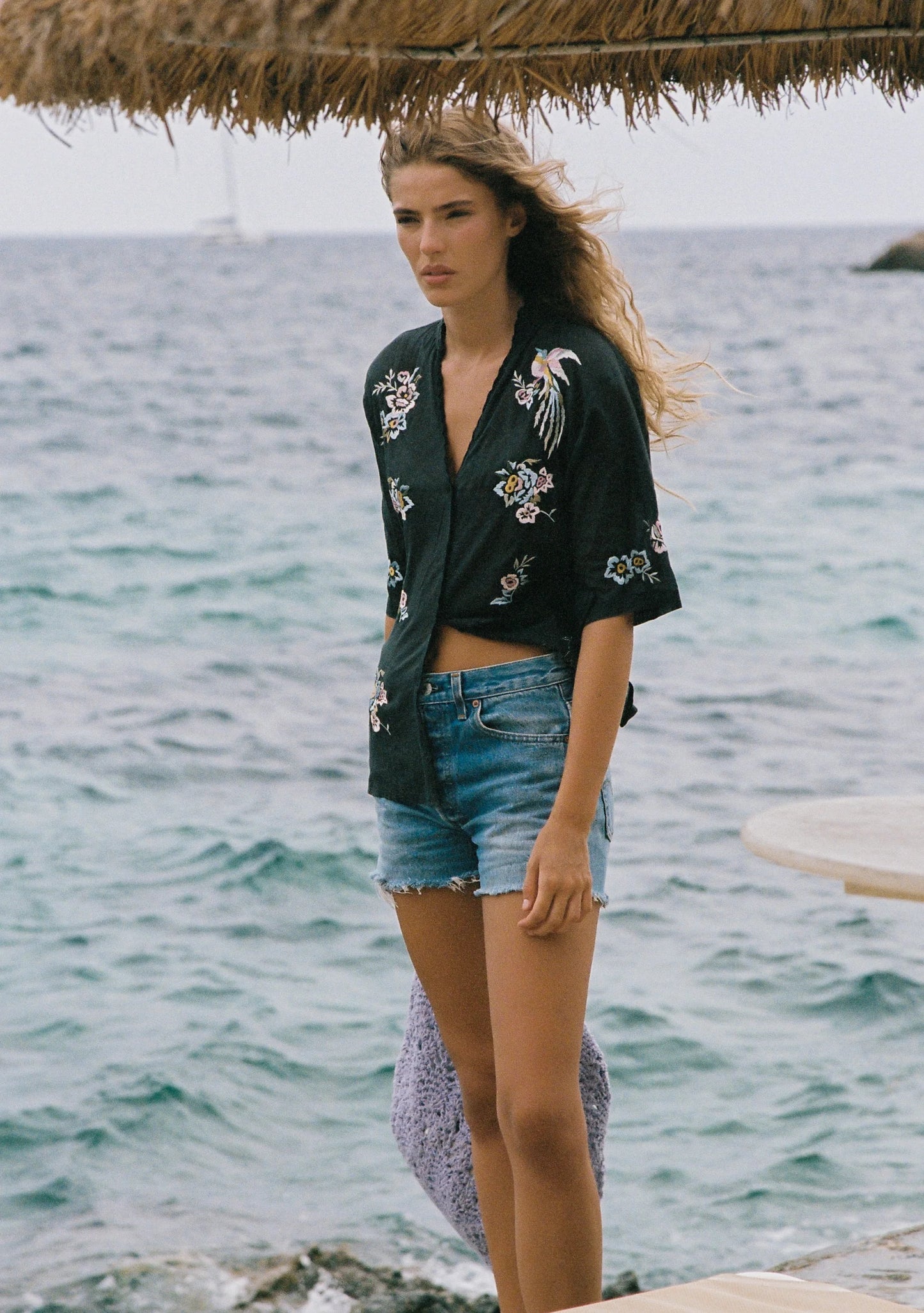 The Viola Blouse in black is another work of art from the talented Balinese artisans that Auguste’s founder, Ebony, has collaborated with for nearly 20 years. A testament to timeless craftsmanship, this blouse features a collar stand with a V-neckline, a center front button closure, and delicate scallop embroidery along the neckline and opening. Intricate embroidered detailing adds to its refined elegance, while the 100% cotton, semi-sheer, non-stretch fabric offers a soft drape and luxurious hand feel. Des