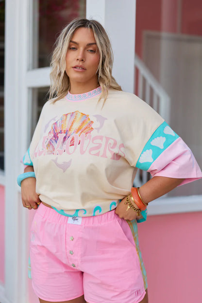 Only Lovers Left - The Shell Club Boxer Short is a bold take on summer nostalgia… easy to wear, instantly fun, and full of thoughtful detail. Crafted from 100% washed cotton, they’re lightweight, durable, and made for endless warm-weather days. Contrast tartan panels run down each side, Mother of Pearl star buttons shimmer at the front, and subtle shell embroidery traces the pocket, a little nod to collecting seaside treasures along the way.&nbsp;