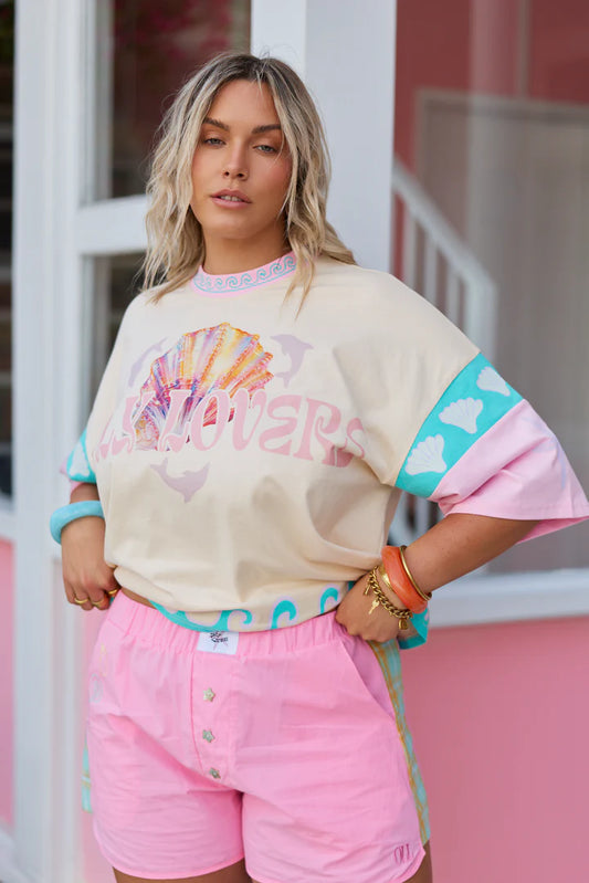 Only Lovers Left - The Shell Club Boxer Short is a bold take on summer nostalgia… easy to wear, instantly fun, and full of thoughtful detail. Crafted from 100% washed cotton, they’re lightweight, durable, and made for endless warm-weather days. Contrast tartan panels run down each side, Mother of Pearl star buttons shimmer at the front, and subtle shell embroidery traces the pocket, a little nod to collecting seaside treasures along the way.&nbsp;