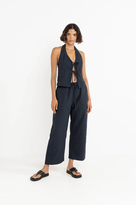 Add a nautical touch to your wardrobe with the Louise Check Halter Top in Navy. Featuring front ties and a smocked back, this piece is perfect for warm days by the water.