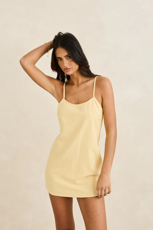 Indulge in timeless appeal with the Classic Slip Dress in Butter. Designed with a sleek neckline and thin self-bind straps, it features adjustable straps for a tailored fit. Whether layered for cooler evenings or worn solo under the sun, this slip mini dress brings effortless elegance to coastal styling. A subtle Classics flag label finishes the look at the side seam.