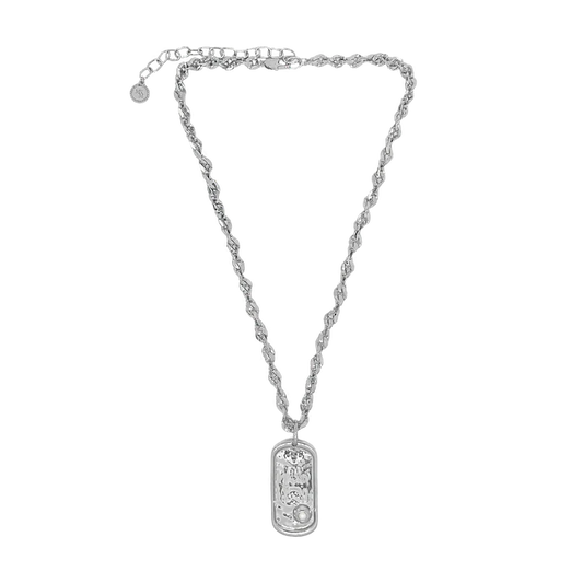 Understated and powerful, the Cypress Necklace in silver is a sculptural tribute to identity, elegance, and the enduring pull of the sea. Crafted with a thick, twisted rope-style chain, it features a modern pendant inspired by the shape of a traditional dog tag—reimagined with softened lines and a refined finish. At its center rests a luminous freshwater pearl, adding a touch of organic beauty.