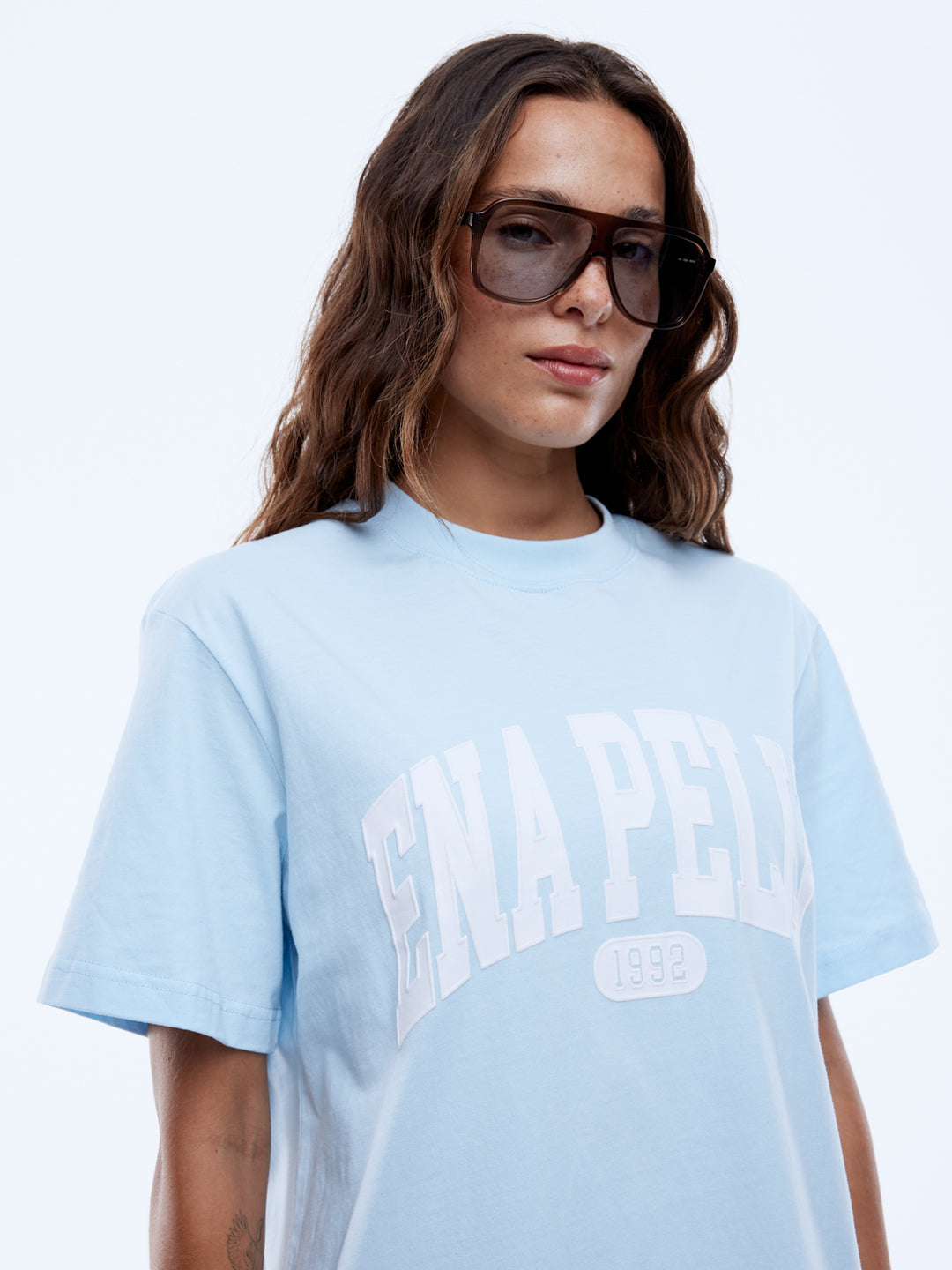 Bold Lines. Casual Rhythm.
The Collegiate Tee is crafted from a recycled-cotton blend in a relaxed cut with a light blue hue. Finished with contrast collegiate graphics in a crisp plastisol print for a modern athletic mood.

Relaxed fit
In house graphic
Short sleeves
Crew neck
Model is 172cm and wears size 8