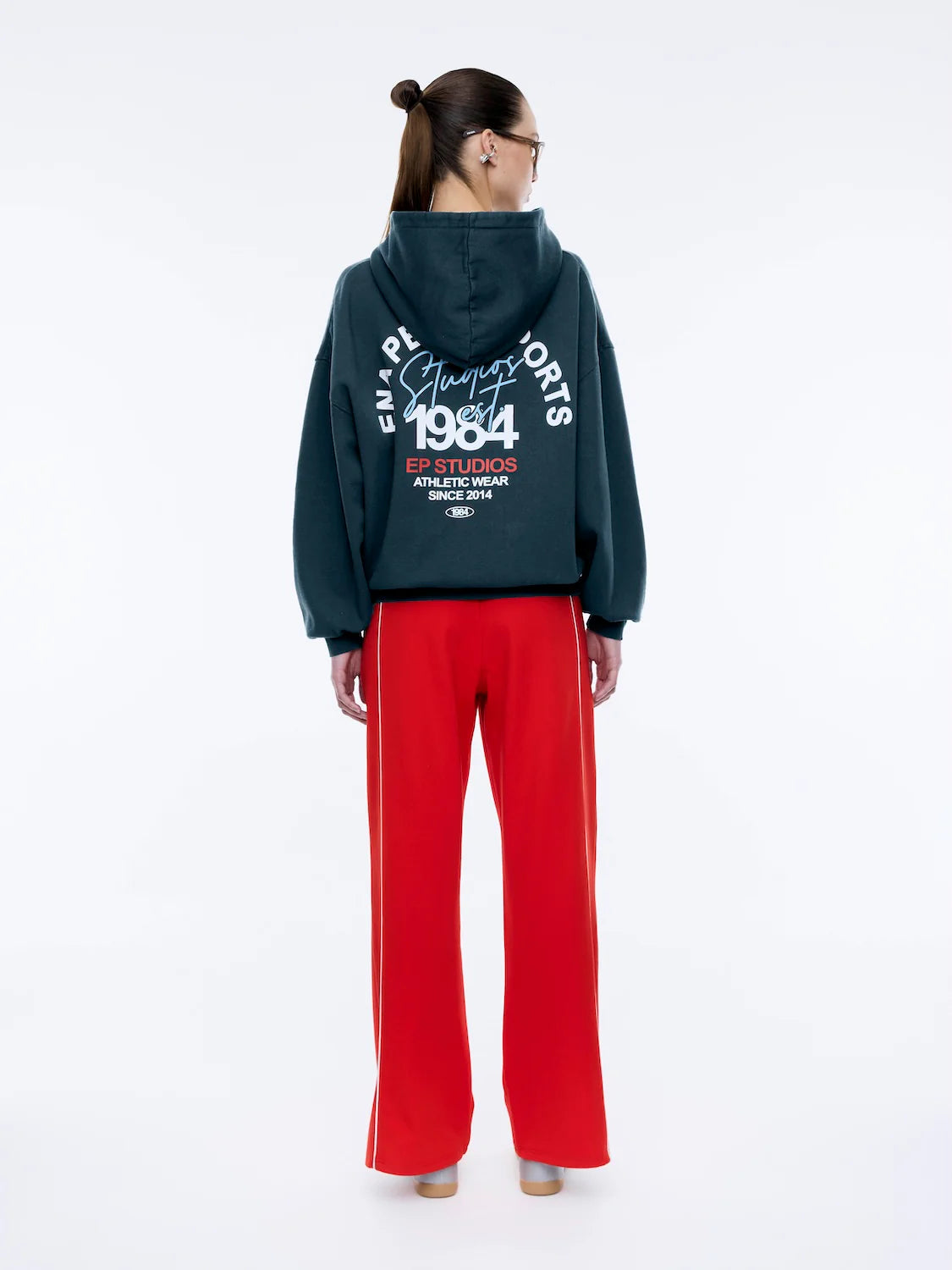 Where sporty meets streetwear cool — the Script Studio Hoodie is your go-to layer for off-duty confidence. Crafted from premium cotton terry in a vintage-washed black, this oversized hoodie features bold collegiate-inspired graphics on both the chest and back, including Ena Pelly’s signature “Studio 1984” motif.