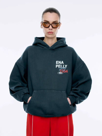 Where sporty meets streetwear cool — the Script Studio Hoodie is your go-to layer for off-duty confidence. Crafted from premium cotton terry in a vintage-washed black, this oversized hoodie features bold collegiate-inspired graphics on both the chest and back, including Ena Pelly’s signature “Studio 1984” motif.