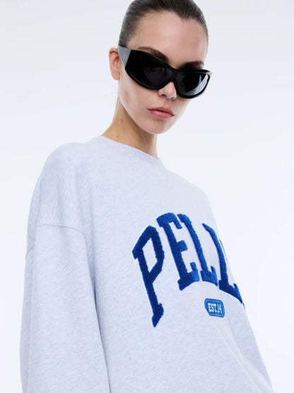 The Anniversary Sweatshirt is crafted from premium cotton terry, offering a soft yet durable texture. Featuring an oversized fit with a crew neckline, ribbed cuffs, and a ribbed neckband, it pairs comfort with elevated style. The exclusive Ena Pelly design is highlighted by a terry applique collegiate print, giving this sweatshirt its distinctive edge.