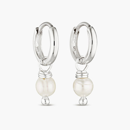 Elevate your style with our Pearl Layla Huggies, a timeless addition to your collection. These earrings feature sterling silver huggies adorned with lustrous freshwater pearls, symbolizing purity, wisdom, and maternal influence. Pearls are known for their calming and balancing properties, making these earrings not just a fashion statement, but also a source of inner peace and harmony.