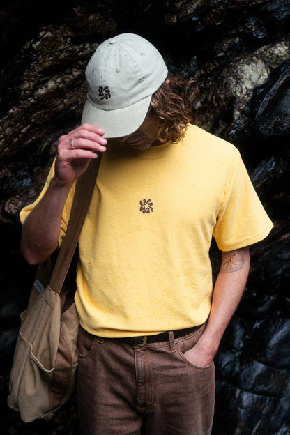 The Traction Cap in Natural features lightweight pigment-dyed twill, a brass adjustable slider, and subtle center front embroidery, making it a timeless accessory.