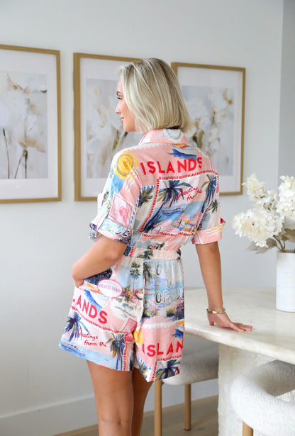 Embrace your adventurous spirit in this striking coastal playsuit that captures the raw energy of windswept shores. Featuring an eye-catching seaside-inspired print, a sharp collar, and a cinched drawstring waist, this piece commands attention with effortless edge. The mid-thigh length shorts offer the perfect balance of boldness and wearability, making it ideal for those ready to make a statement. Whether you're heading to a beach gathering or turning heads at a casual night out, this playsuit delivers 