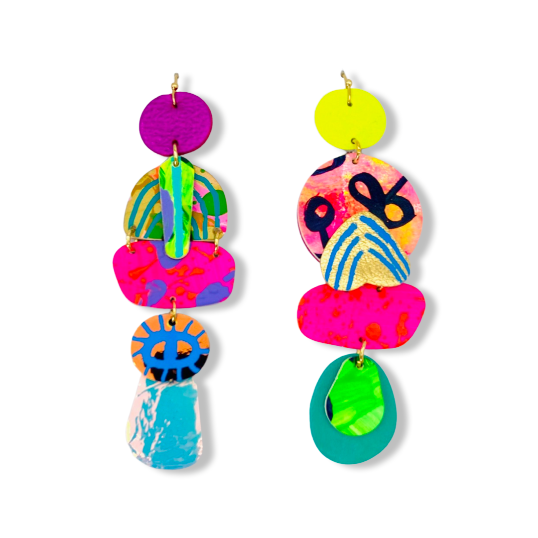 A striking pair of mix matched yet complementary handmade leather earrings. Bold, bright use of colour mixed with iridescent and metallic highlights. Hung from golden stainless steel hooks.