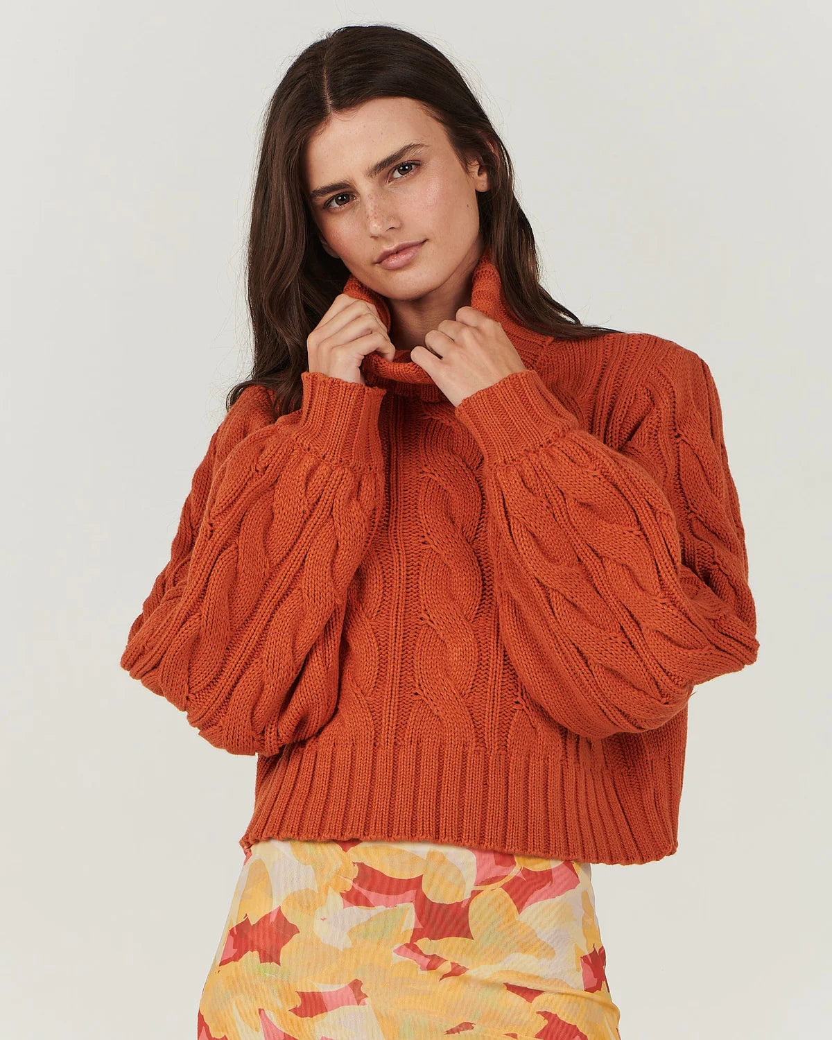 In a warm amber hue, this gorgeous cable knit sweater by Charlie Holiday features a crop body with slouchy blouson sleeves. A beautiful knit you can dress up or down, team it with a floral maxi skirt or with high-waisted jeans and ankle boots.