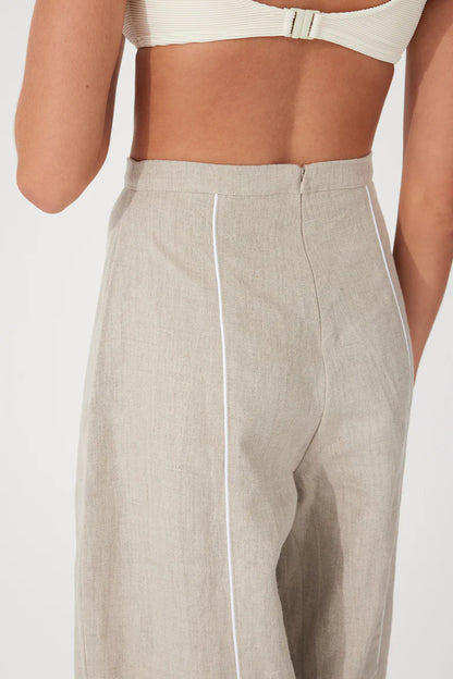 The Husk Contrast Linen Pant by Zulu & Zephyr is effortlessly wearable, to be dressed up or down, featuring a high fixed waistband with back zip closure, a loose tailored leg, and contrast piping detailing.