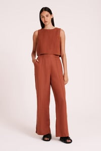 The Amani Tailored Linen pant in amber is made from a premium linen which has been washed for a smooth, soft hand feel. The silhouette is a classic tailored fit with a high waist, wide legs and length finishing full length. Features include a functioning fly front, pin stitch on front leg and side seam pockets. 