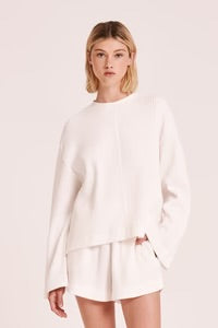 The Rani Waffle Top in Salt is made from a textured cotton fabric with a soft hand feel. The silhouette is a boxy fit with length finishing on the hip and wide long sleeves. Features include a crew neck and a stepped hem with side slits.&nbsp;