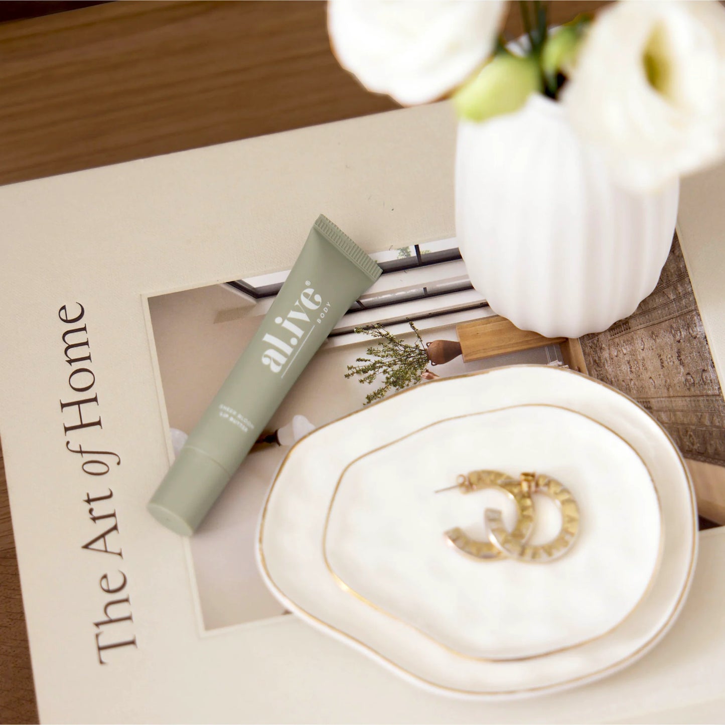 A nourishing 15ml Sheer Bloom Lip Butter enriched with Vitamin E and nourishing oils to support hydration and softness. Lightly scented with a soft, sweet Ivory Bloom aroma inspired by white florals.