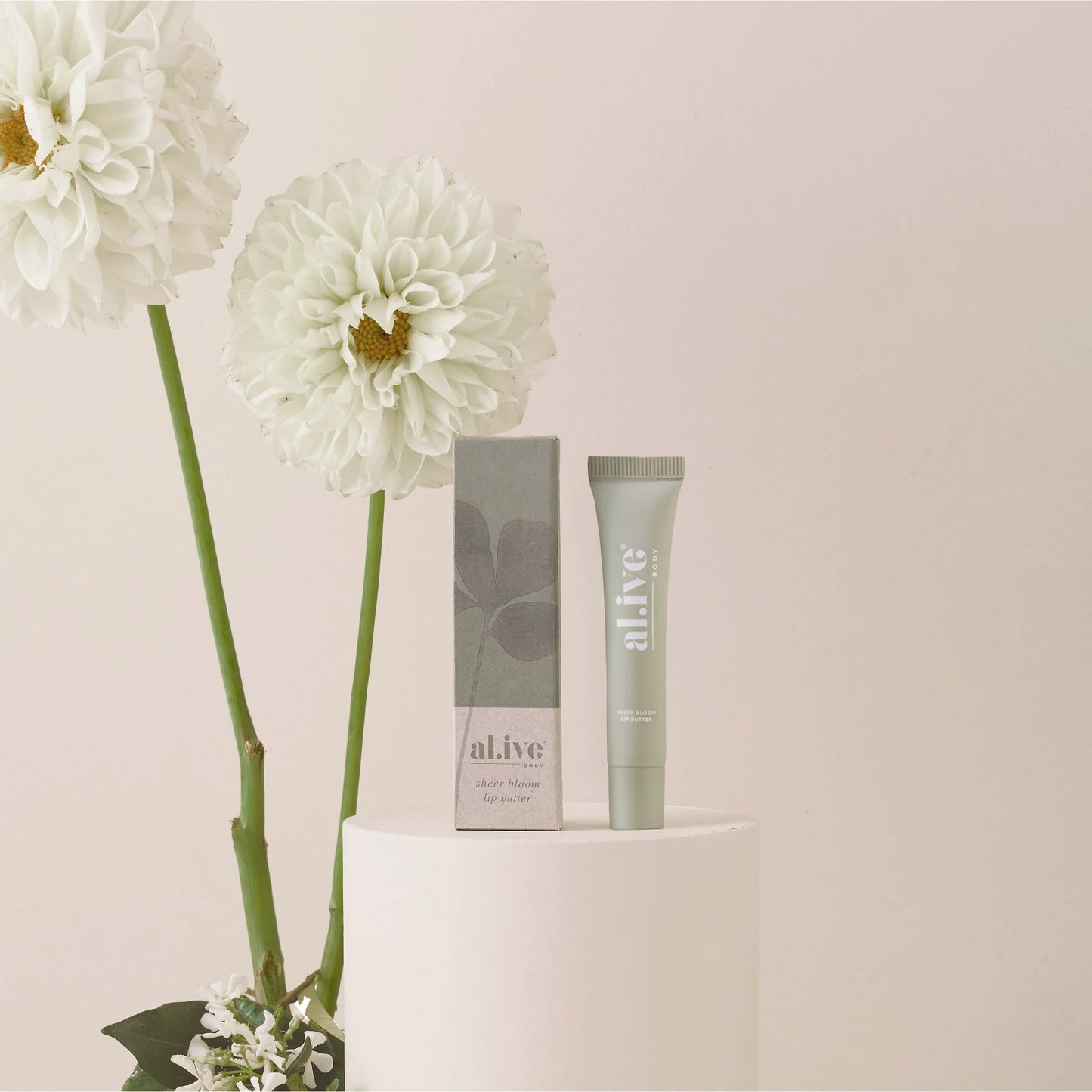 A nourishing 15ml Sheer Bloom Lip Butter enriched with Vitamin E and nourishing oils to support hydration and softness. Lightly scented with a soft, sweet Ivory Bloom aroma inspired by white florals.