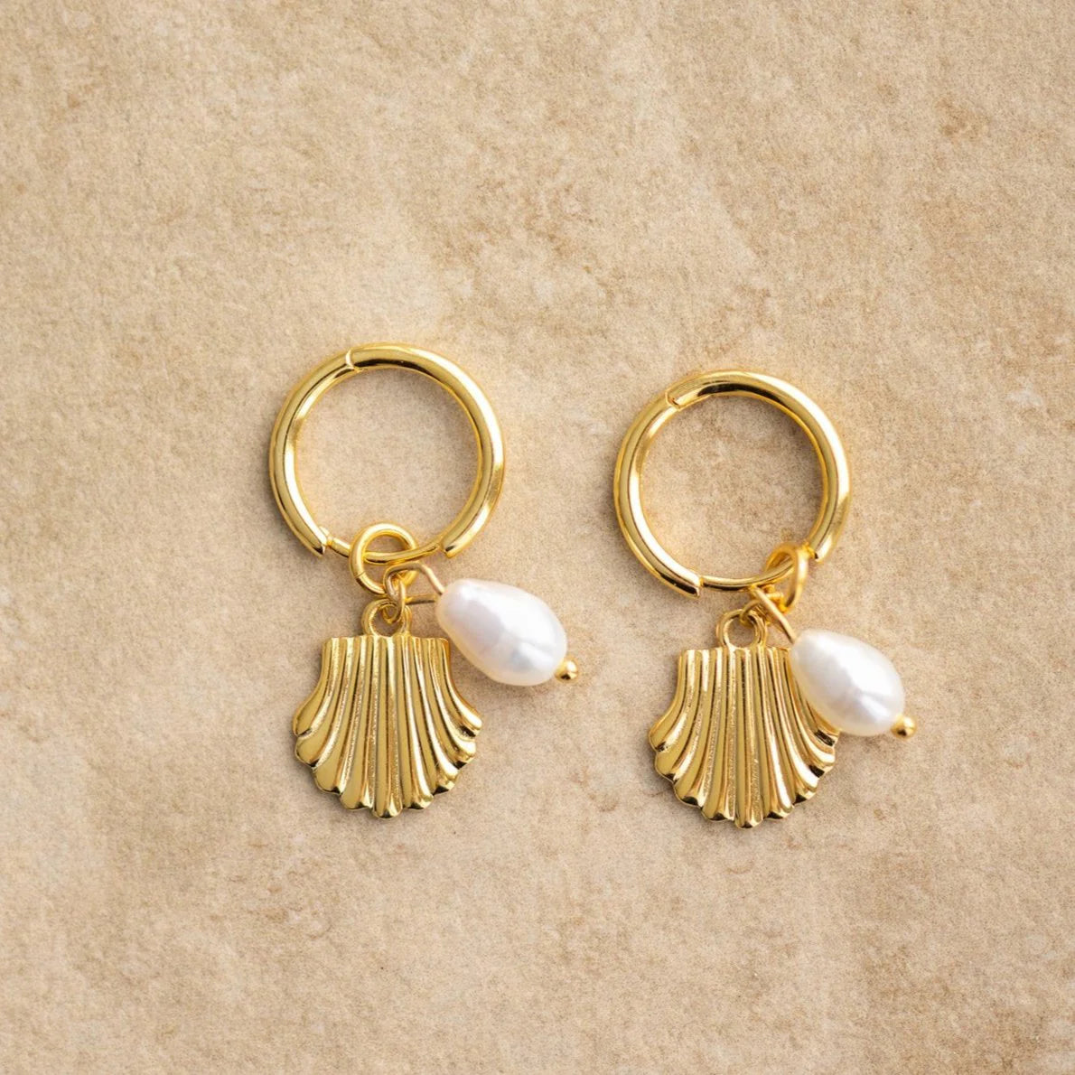 The ISLA earrings will add some seaside charm to any outfit. Grab a pair and shell-abrate your fashion sense!

S925 Gold Plated Sterling Silver
Freshwater pearl/Seashell Charm
Lead,Nickel &amp; Tarnish Free
Hypoallergenic
Measures 3cm in Length