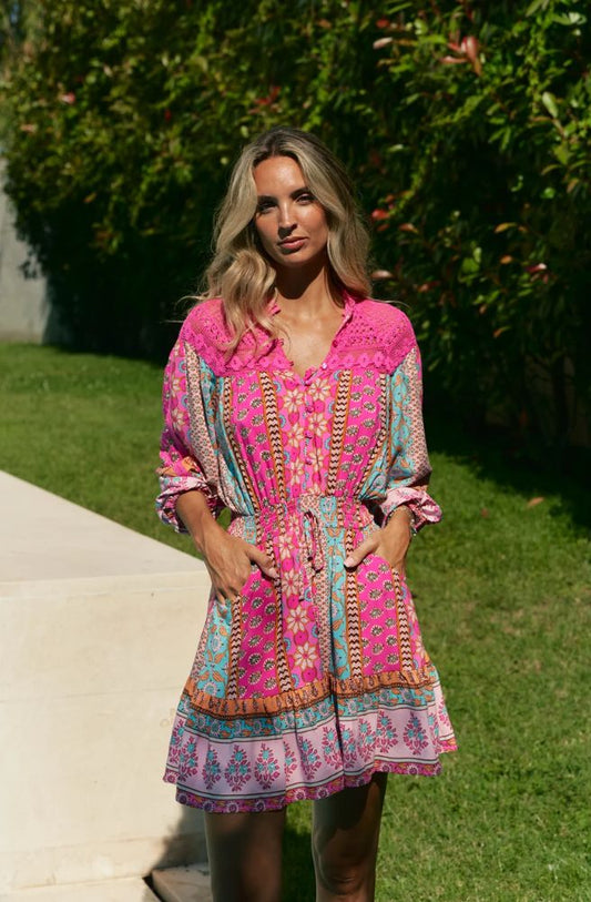 Feminine, vibrant, and effortlessly chic – the Cedella Print Olivia Mini Lace Dress is your go-to for sunshine days and balmy evenings. Designed in a flattering mini length, this dress features a striking mix of bold pinks, turquoise, and warm earthy tones in Jaase’s signature bohemian print.