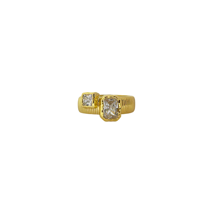 Elegant with a hint of edge, the Maia Ring is a modern relic inspired by radiant ancient craftsmanship. Featuring a ribbed, circular band in gold, it holds two rectangular cubic zirconia stones in textured bezel settings—designed to catch the light like sunlit waves.