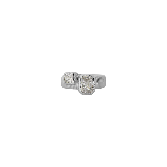 Sculptural and serene, the Maia Ring in silver brings together ancient influence and modern clarity. Its ribbed circular band is crafted in a cool silver-tone finish, framing two rectangular cubic zirconia stones in molten-textured bezel settings—subtle sparkles that evoke the shimmer of starlight on water.