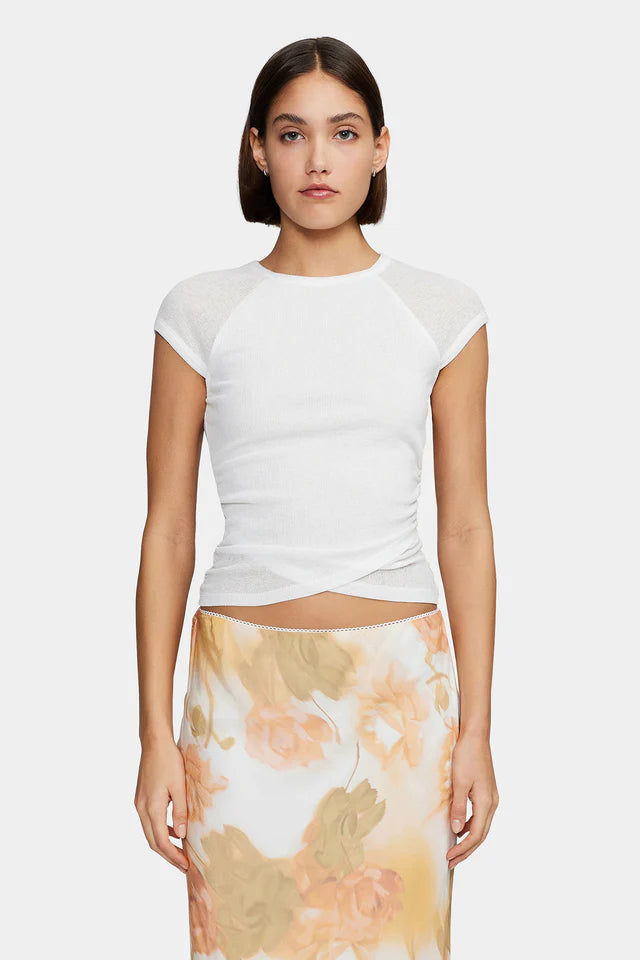 The Martha Baby Tee has a gathered waist for shaping, a crossover hemline detail and capped sheer sleeves. The tee is the perfect elevated staple to pair back with your wardrobe favourites.