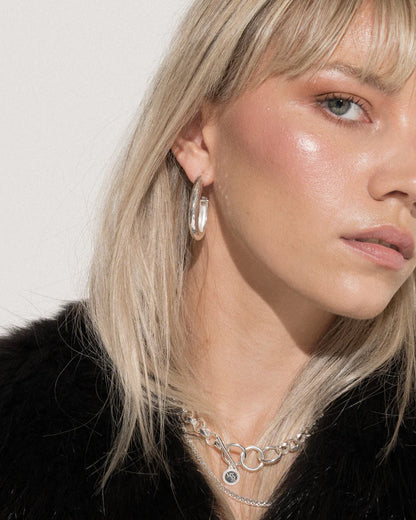 If you need a hoop to take your daily style up a notch, or if you'd like a few more pieces to complete your collection, we present to you the ever popular Kitty Hoops, now in Silver! These oval shaped hoops exude attitude and can provide a bold flair to any look. Whether you're headed out on the town or just grabbing coffee with a friend, let these statement earrings add a bit of extra sass to your style. Remember, you can never be too much honey!