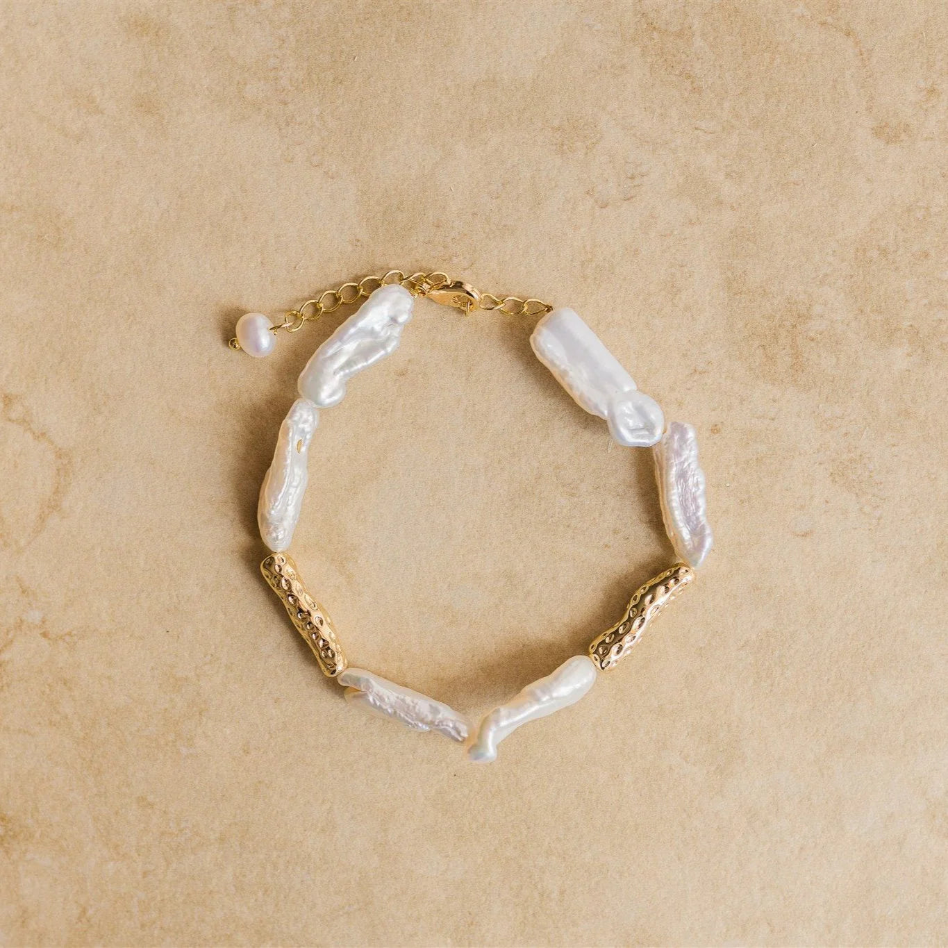 Introducing the MALAKAI Bracelet - This stunning bracelet features pure baroque pearls that bring a touch of elegance to any outfit. Pair this perfectly with the matching necklace and earrings!

18Kt Gold Vermeil
Crushed Gold/Pure Baroque Pearl
Lead,Nickel &amp; Tarnish Free
Hypoallergenic
Measures 16cm + 3cm
Weighs 8.8g