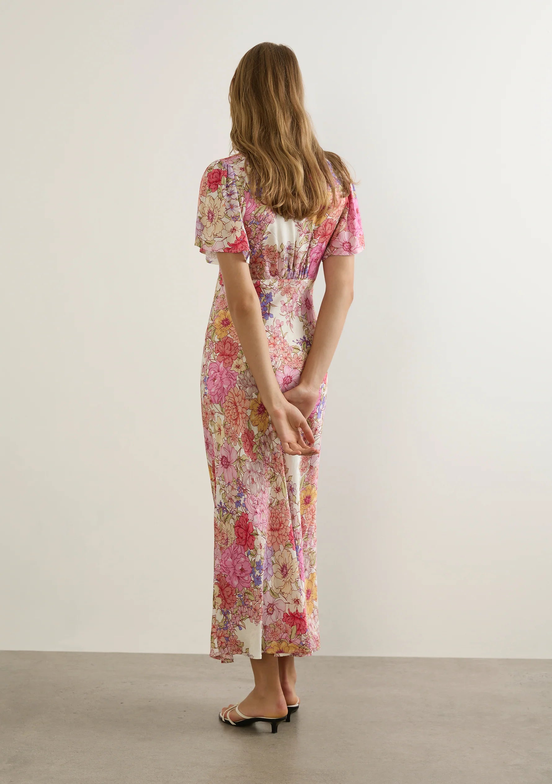 The Calais Midi Dress in the new Ode Floral is a fresh take on the best-selling Pamela Midi Dress, designed for effortless elegance. Featuring a V-neckline, under-bust seam with soft gathers, and short flutter sleeves, this dress offers a feminine and flattering fit. The bias-cut silhouette beautifully skims the body, enhancing natural curves, while the invisible side zip fastening ensures a seamless finish. Crafted from 100% viscose in a floral satin-finish jacquard, the lightweight, non-stretch fabric has