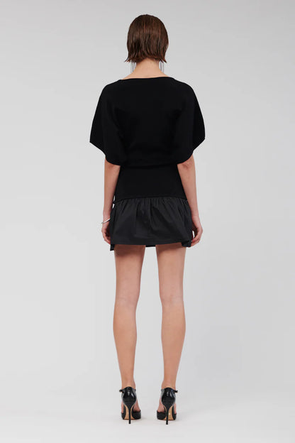 The Naples Drop Waist Mini Dress includes a straight neckline, and in striking classic black exudes a bold yet refined elegance that elevates your ensemble. Its flared skirt simply sits at the hips, making it an ideal choice for both daytime and evening events. The dress is further enhanced by loose sleeves that fall above the elbow, contributing to a relaxed and sophisticated figure.