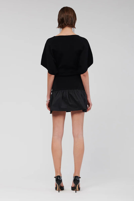 The Naples Drop Waist Mini Dress includes a straight neckline, and in striking classic black exudes a bold yet refined elegance that elevates your ensemble. Its flared skirt simply sits at the hips, making it an ideal choice for both daytime and evening events. The dress is further enhanced by loose sleeves that fall above the elbow, contributing to a relaxed and sophisticated figure.