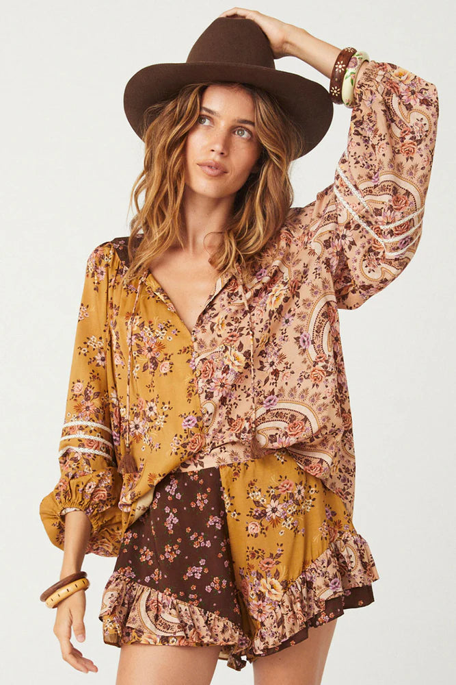 The Melody Blouse in Woodstock is crafted for the rebel hearts. Our newest blouse features a unique patchwork print placement from the design team ~ our honeyed amber print to one side, our rambling florals in pink and cream to the other with our retro brown and ditsy floral print across the back yoke complete this statement style and echo the free spirit of our rebel muse. Inserted ladder lace frames the billowing sleeves, a button down front offers styling versatility while the neck line includes ties wit