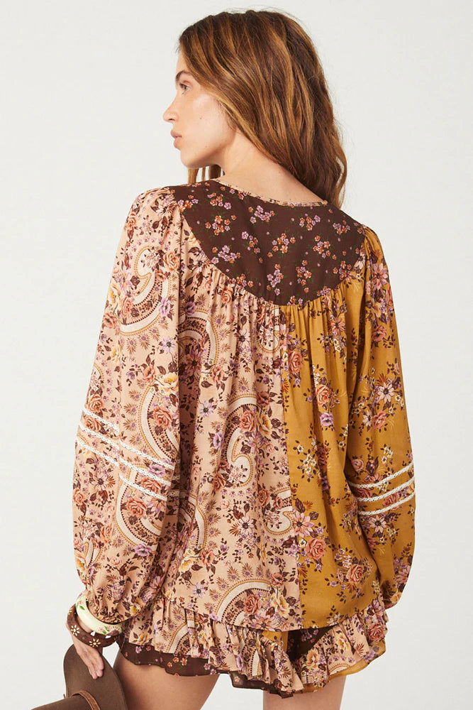 The Melody Blouse in Woodstock is crafted for the rebel hearts. Our newest blouse features a unique patchwork print placement from the design team ~ our honeyed amber print to one side, our rambling florals in pink and cream to the other with our retro brown and ditsy floral print across the back yoke complete this statement style and echo the free spirit of our rebel muse. Inserted ladder lace frames the billowing sleeves, a button down front offers styling versatility while the neck line includes ties wit