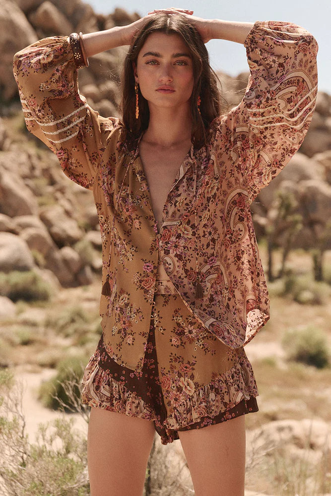 The Melody Blouse in Woodstock is crafted for the rebel hearts. Our newest blouse features a unique patchwork print placement from the design team ~ our honeyed amber print to one side, our rambling florals in pink and cream to the other with our retro brown and ditsy floral print across the back yoke complete this statement style and echo the free spirit of our rebel muse. Inserted ladder lace frames the billowing sleeves, a button down front offers styling versatility while the neck line includes ties wit