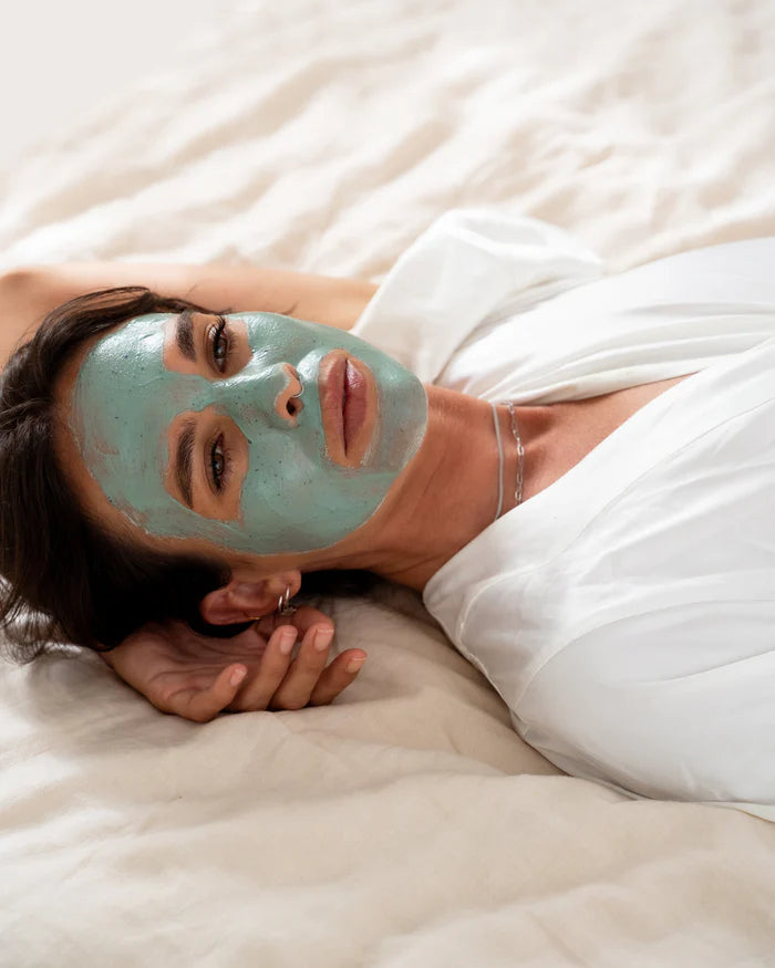 Our Australian-made Green Smoothie Clay Mask blends purifying kaolin clay and arrowroot powder with nutrient-rich spirulina, soothing aloe vera, and antioxidant-packed kale to gently cleanse pores and refresh tired skin. Nourishing coconut and hydrating sunflower oils help soften and replenish, while bergamot, jasmine, and vanilla add a light, natural aromatherapy experience. Presented in sustainable packaging, this luxury face mask is free from synthetic ingredients, supporting a healthy, glowing complexio