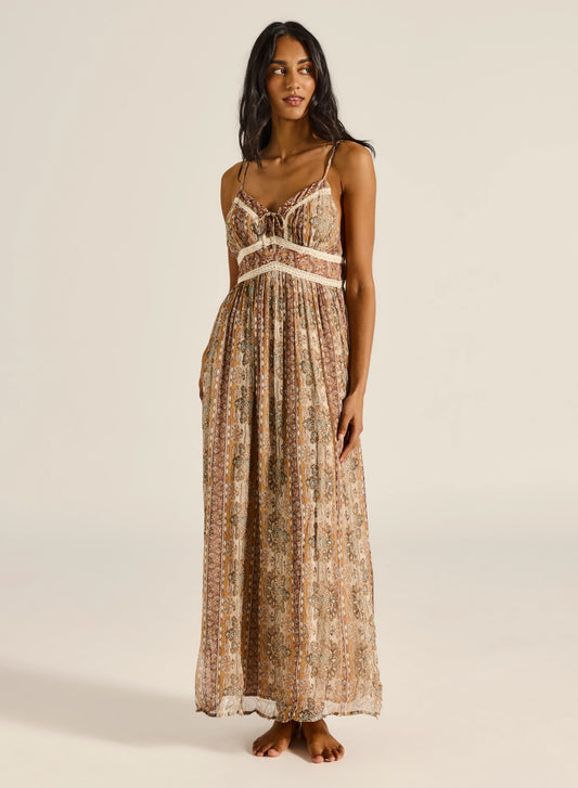 This maxi dress is crafted from a soft, sheer fabrication with an internal slip for comfortable wear. A fitted bodice flows into a gently gathered skirt, creating a beautifully flattering silhouette. Designed with a delicate tie-front detail, refined lace accents, and an invisible zip at the back, this piece blends elegance with effortless femininity.