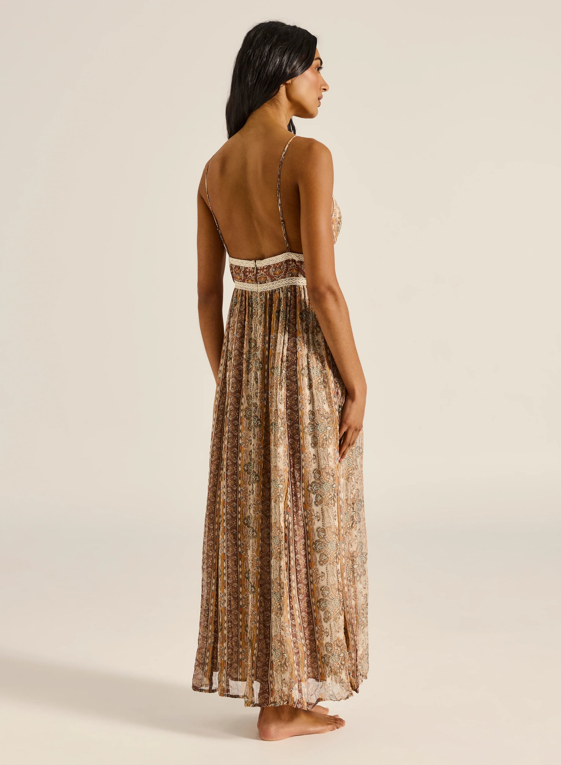 This maxi dress is crafted from a soft, sheer fabrication with an internal slip for comfortable wear. A fitted bodice flows into a gently gathered skirt, creating a beautifully flattering silhouette. Designed with a delicate tie-front detail, refined lace accents, and an invisible zip at the back, this piece blends elegance with effortless femininity.