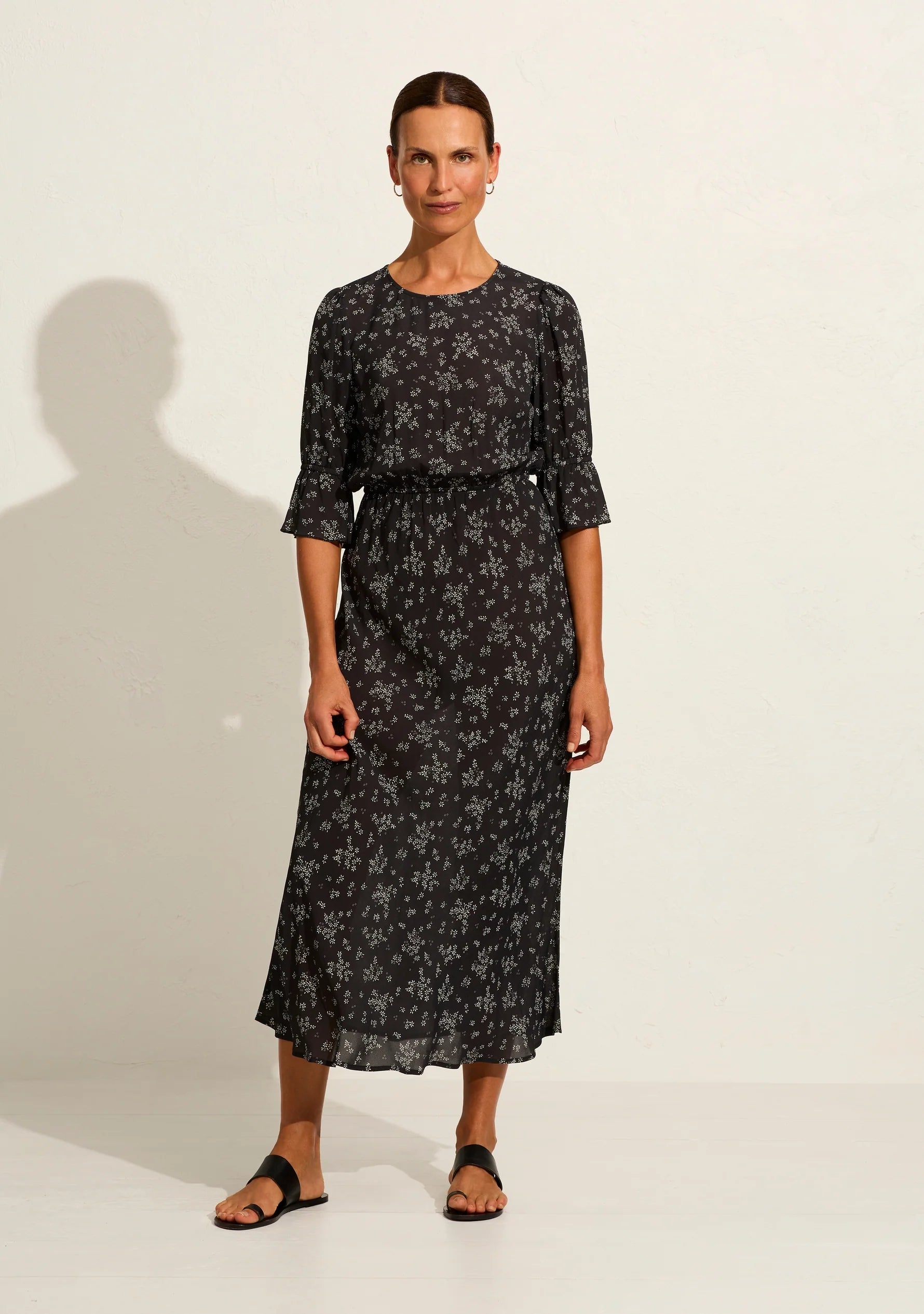 The Aruna midi dress in classic black Maeve print is one of our simple and elegant core pieces, featuring a round neckline, short sleeves with frill, an elasticated waistband, and a blouson top flowing into a flattering bias-cut skirt that falls into a draped hem. What's not to love?