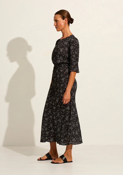 The Aruna midi dress in classic black Maeve print is one of our simple and elegant core pieces, featuring a round neckline, short sleeves with frill, an elasticated waistband, and a blouson top flowing into a flattering bias-cut skirt that falls into a draped hem. What's not to love?