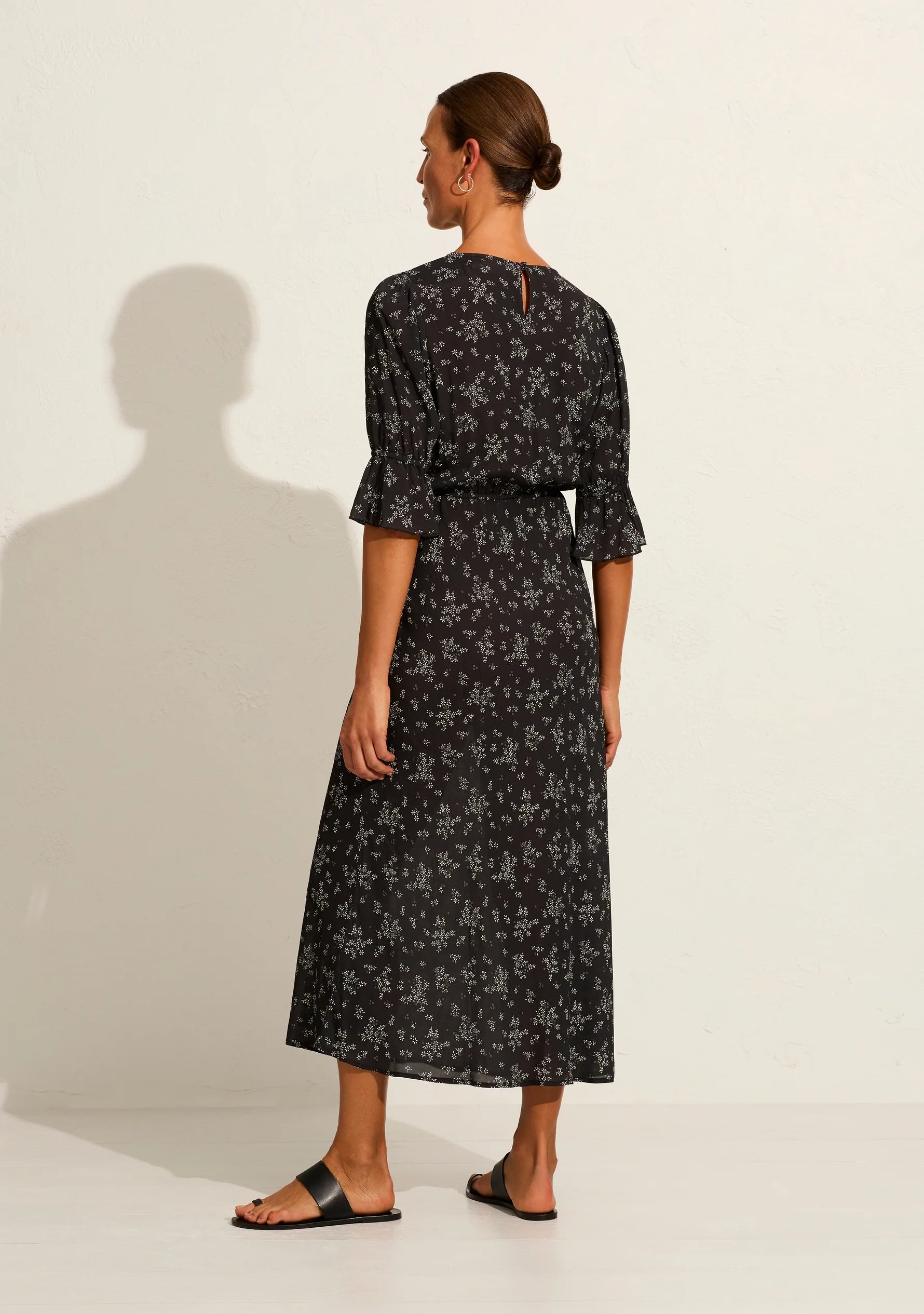 The Aruna midi dress in classic black Maeve print is one of our simple and elegant core pieces, featuring a round neckline, short sleeves with frill, an elasticated waistband, and a blouson top flowing into a flattering bias-cut skirt that falls into a draped hem. What's not to love?