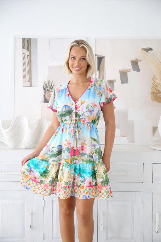 Bright, playful, and made for sunshine days — the Summer Mini Dress is the ultimate vacation-ready piece. Bursting with tropical charm, this dress features a lively coastal-inspired print with vibrant florals, ocean hues, and a fun checked border that instantly lifts your mood.